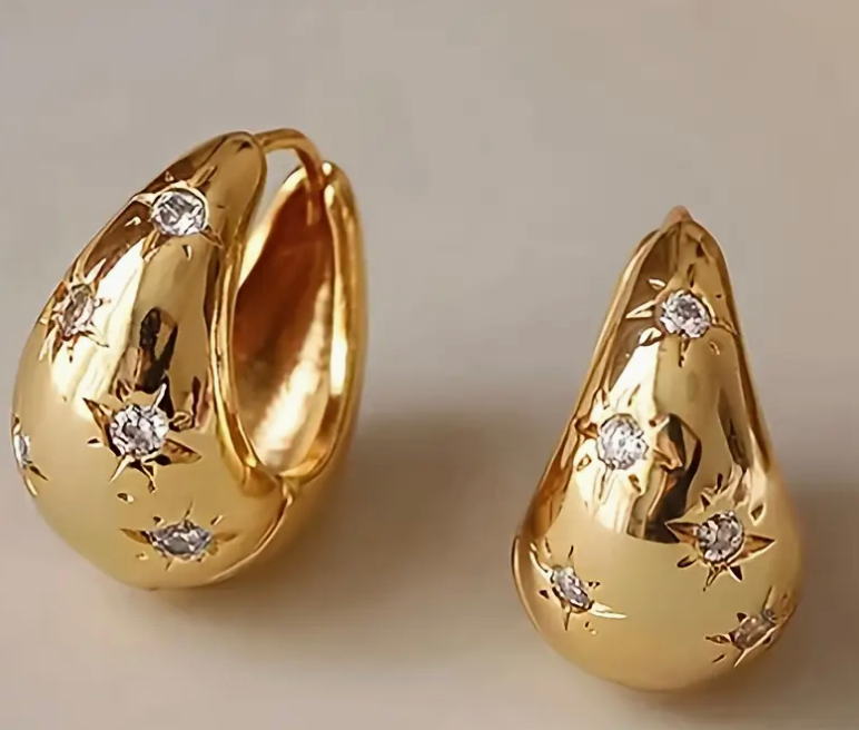 Gold drop star earrings with 18k gold plating and cubic zirconia.