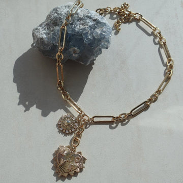 Gold Heart Love Necklace with pave heart charm, sun pendant, and cubic zirconia on a chunky paperclip chain.