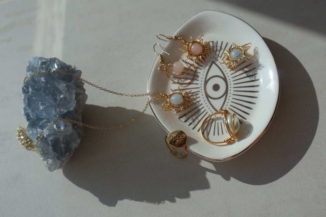 Handmade Gemstone Sun and Moon Earrings with intricate wire-wrapped design placed on a crystal.