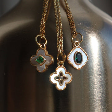 Gold necklace with pearl four-leaf clover pendant on an adjustable chain.