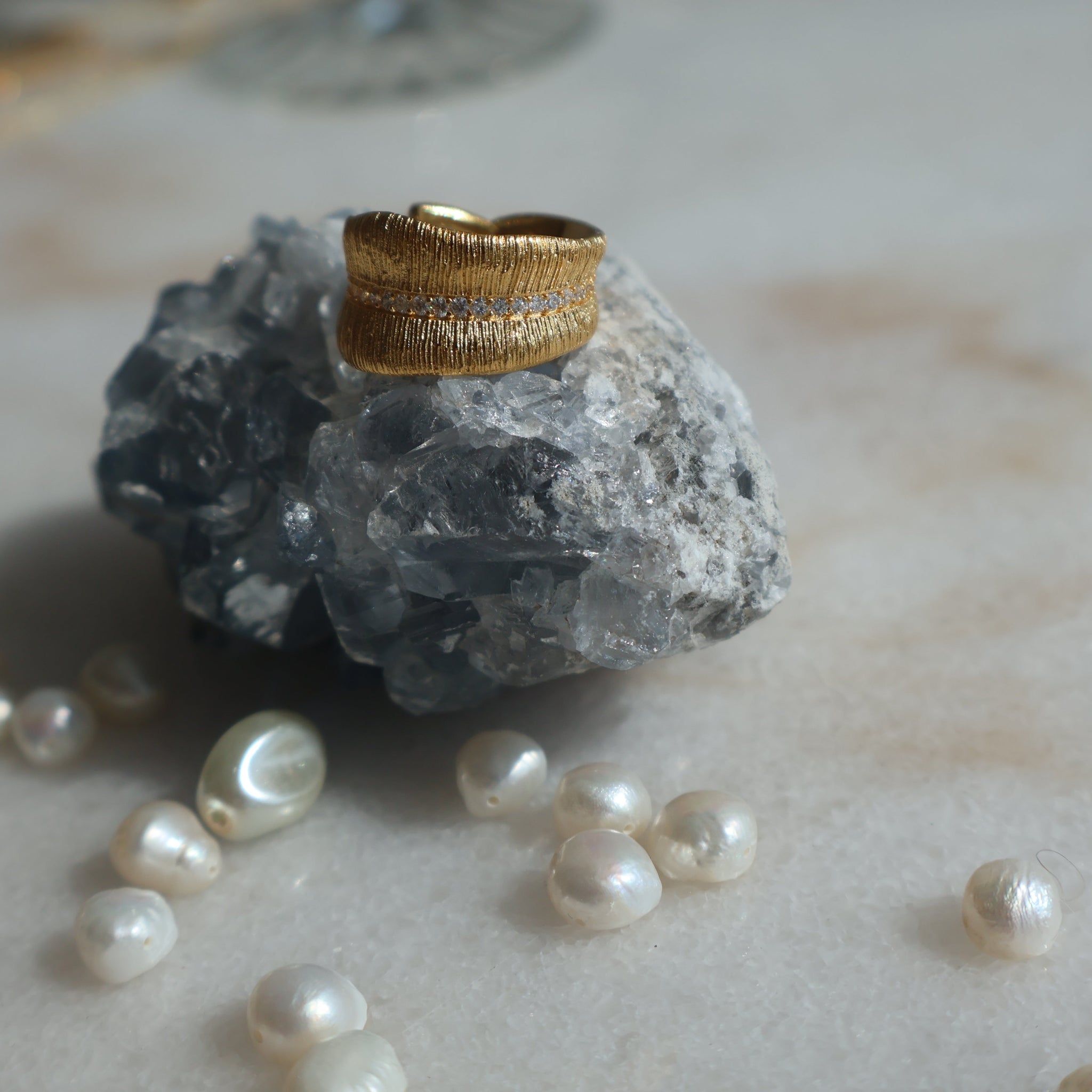Gold Leaf Ring with Zirconia stones on rock, surrounded by pearls.