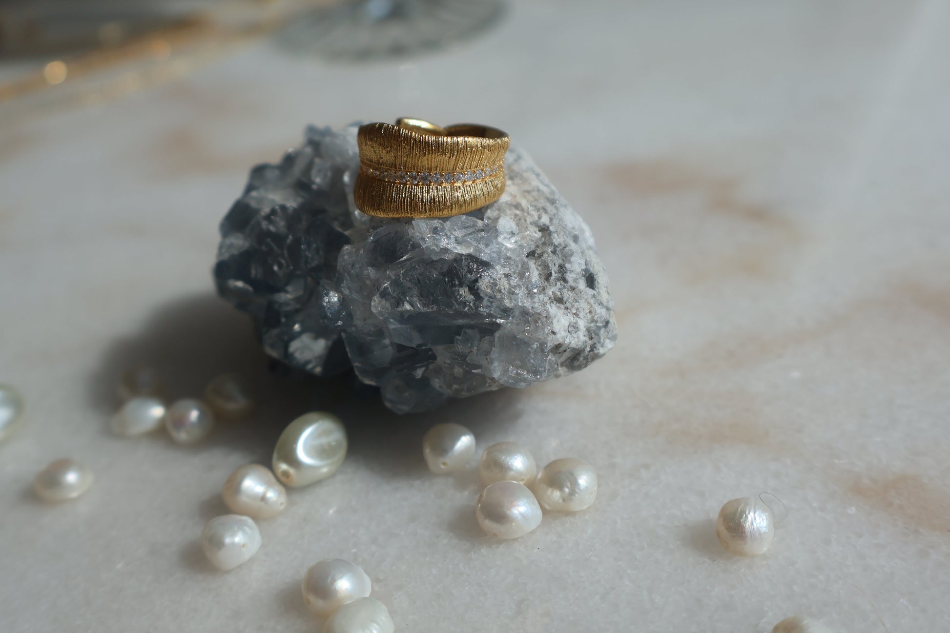 Gold Leaf Ring with Zirconia stones on rock, surrounded by pearls.