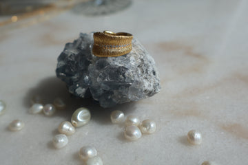 Gold Leaf Ring with Zirconia stones on rock, surrounded by pearls.