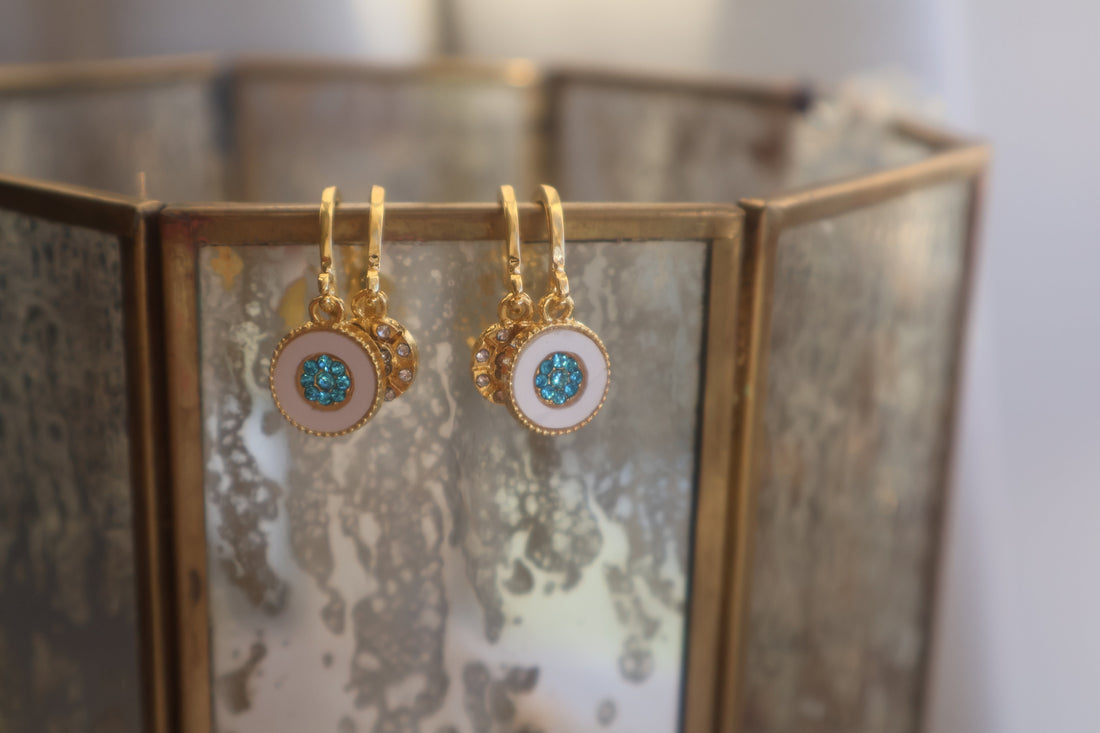 Gold hoop earrings with mosaic turquoise rhinestone and delicate floral design, displayed with crystals.