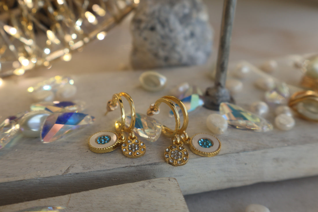 Gold hoop earrings with mosaic turquoise rhinestone and delicate floral design, displayed with crystals.