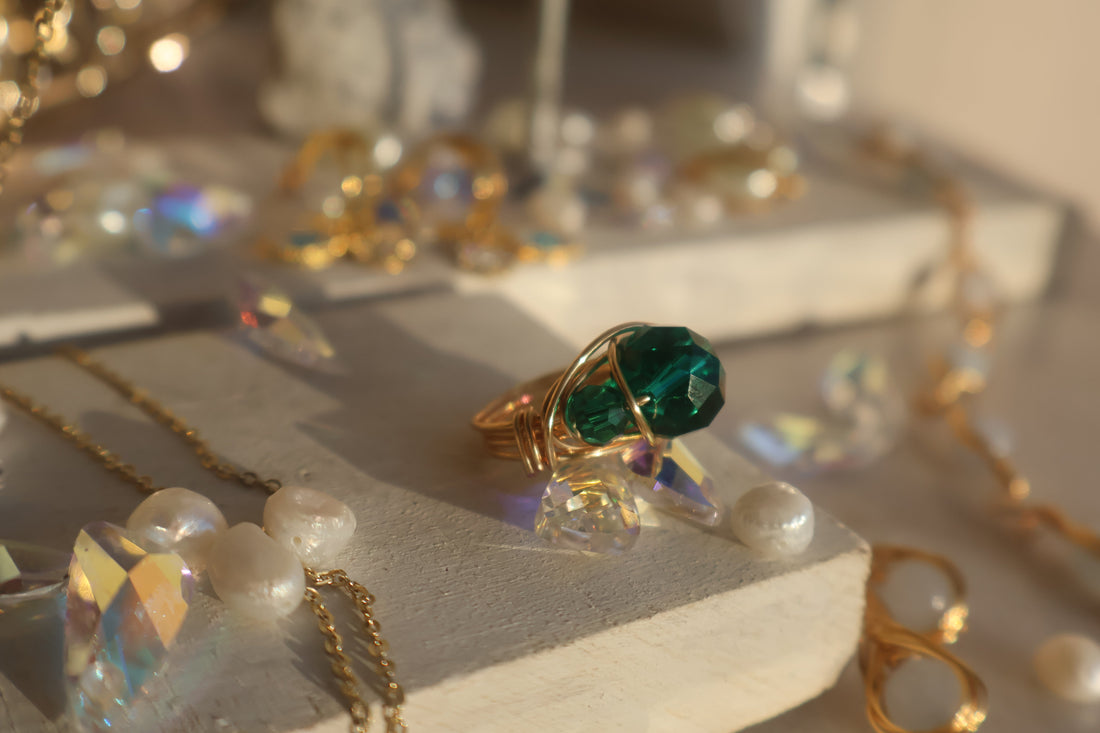 Gold Emerald Green Bead Ring with copper wire wrapping on marble background.