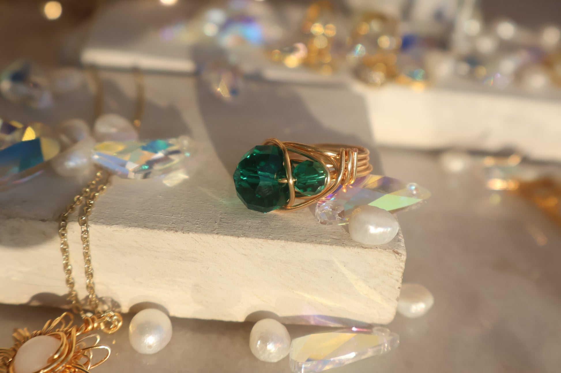 Gold Emerald Green Bead Ring with handcrafted copper wire wrap design, featuring a smooth round bead and adjustable fit, stylishly displayed on light surface.
