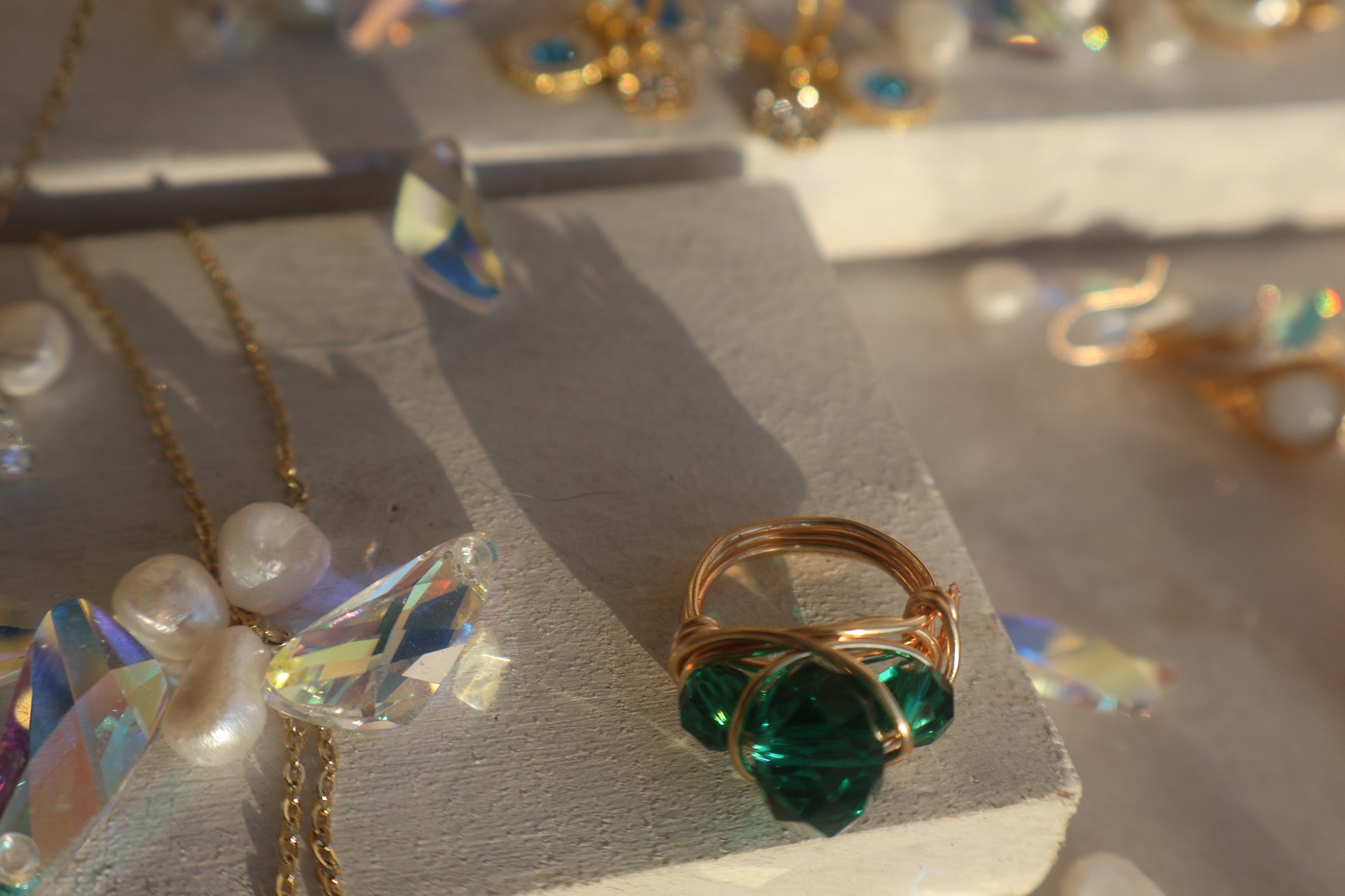 Gold Emerald Green Bead Ring with copper wire wrap on textured surface.