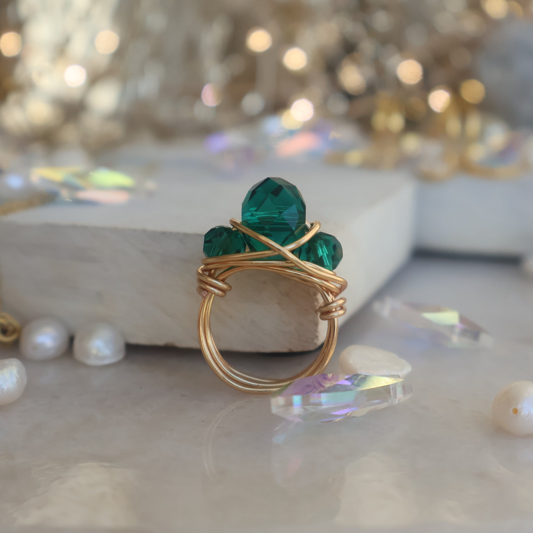 Gold Emerald Green Bead Ring with copper wire wrapping on marble background.